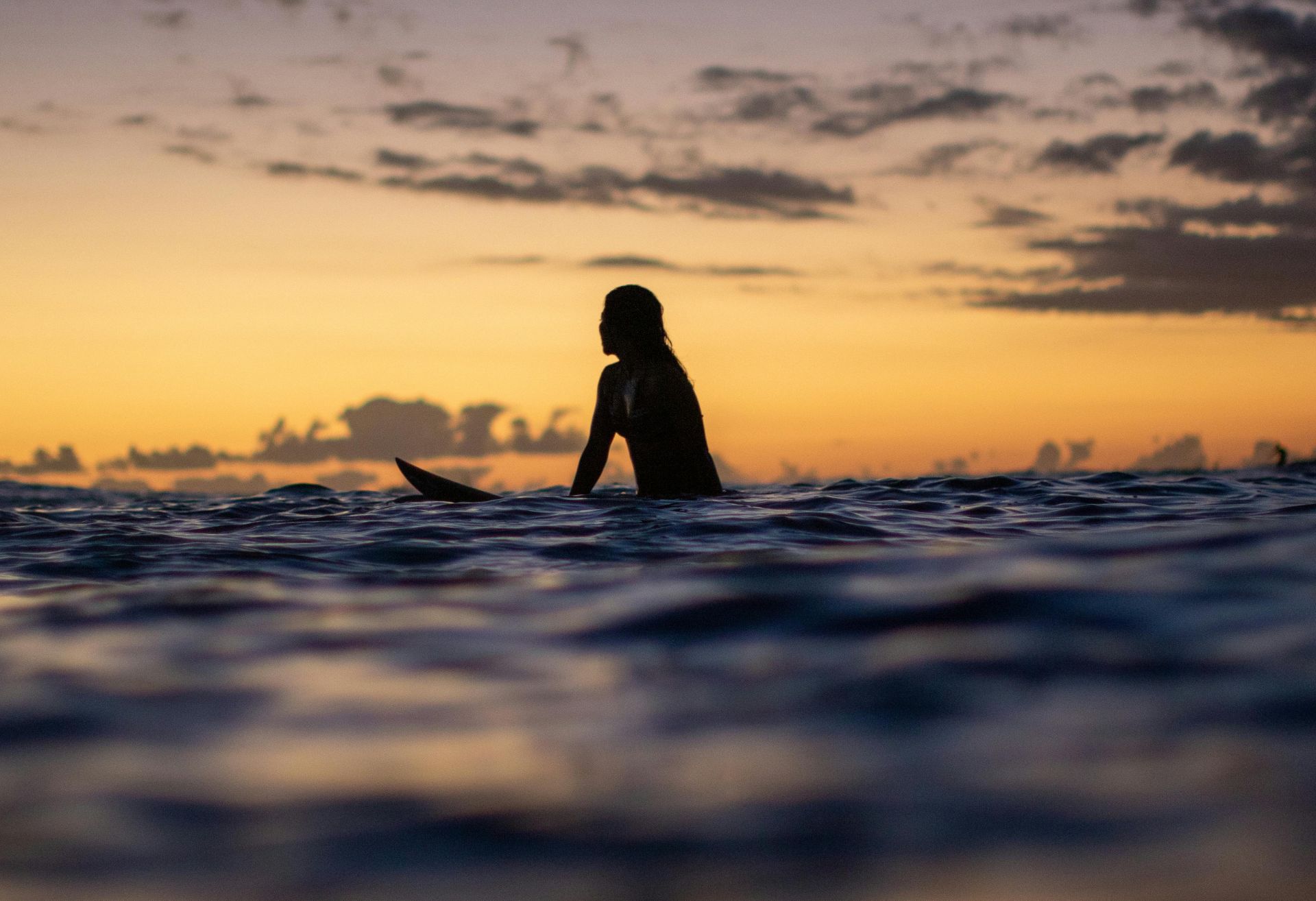 Image of a female surfer at sea waiting for a wave